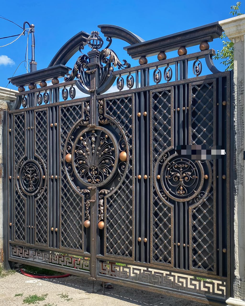 Wrought iron entrance gate with decorative steel detailing